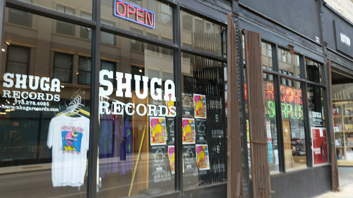 Shuga Records storefront at 1272 North Milwaukee Avenue in Chicago, with white logos across its glass windows.
