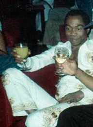 Fela Kuti seated with a drink