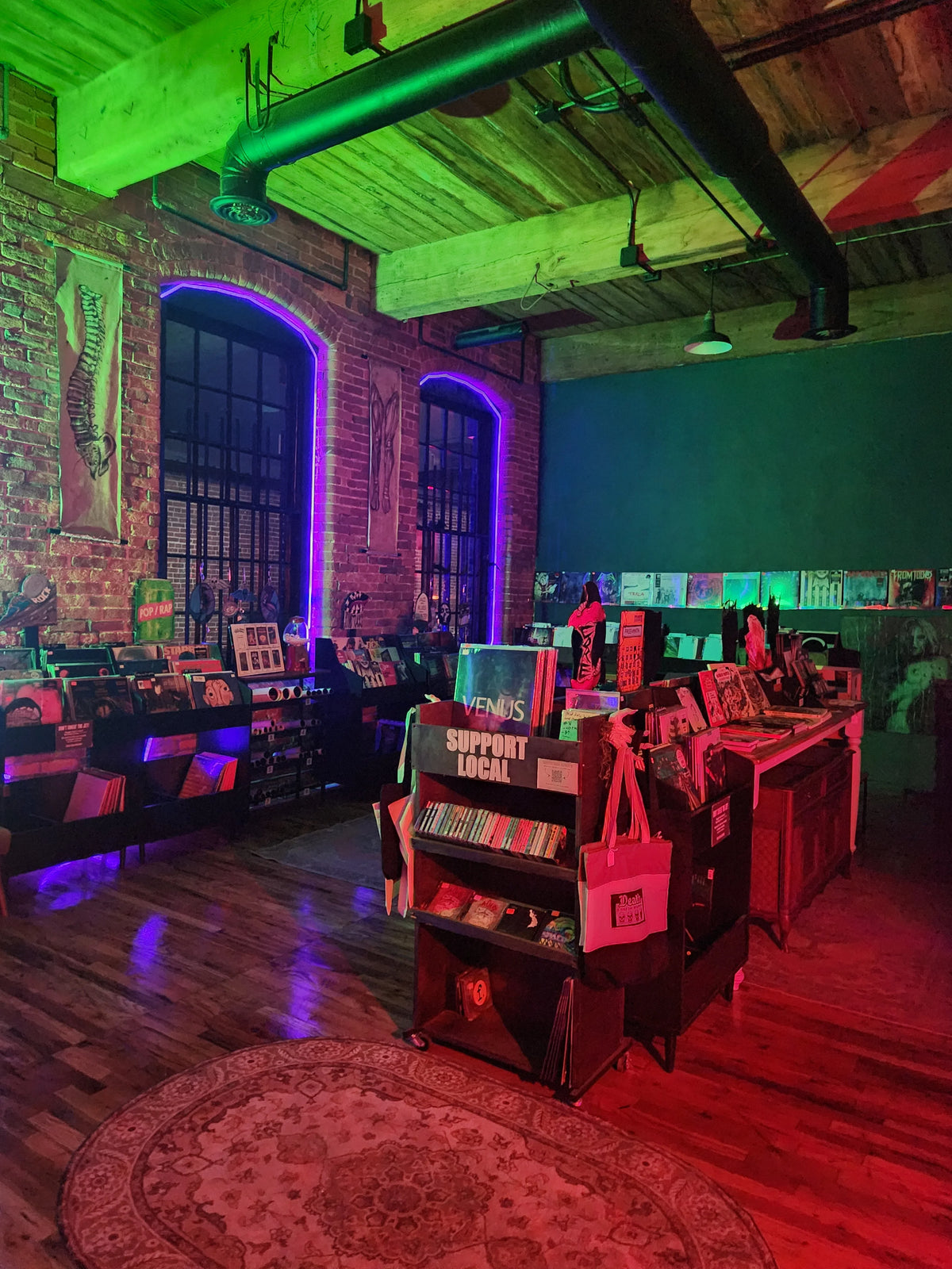 Vinyl bins beside brick walls and arched windows inside Dead End Records in Marathon Village.