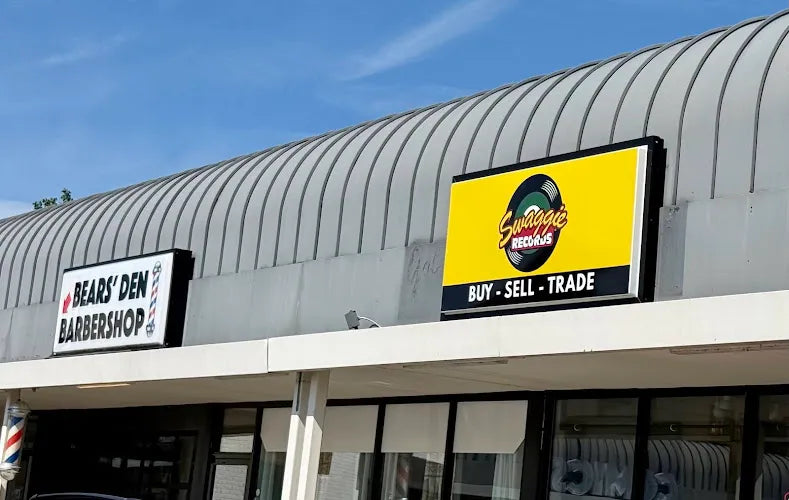 Yellow Swaggie Records sign beside Bears’ Den Barbershop at the Donelson storefront.
