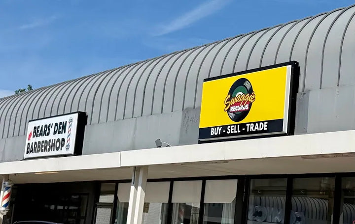 Yellow Swaggie Records sign beside Bears’ Den Barbershop at the Donelson storefront.